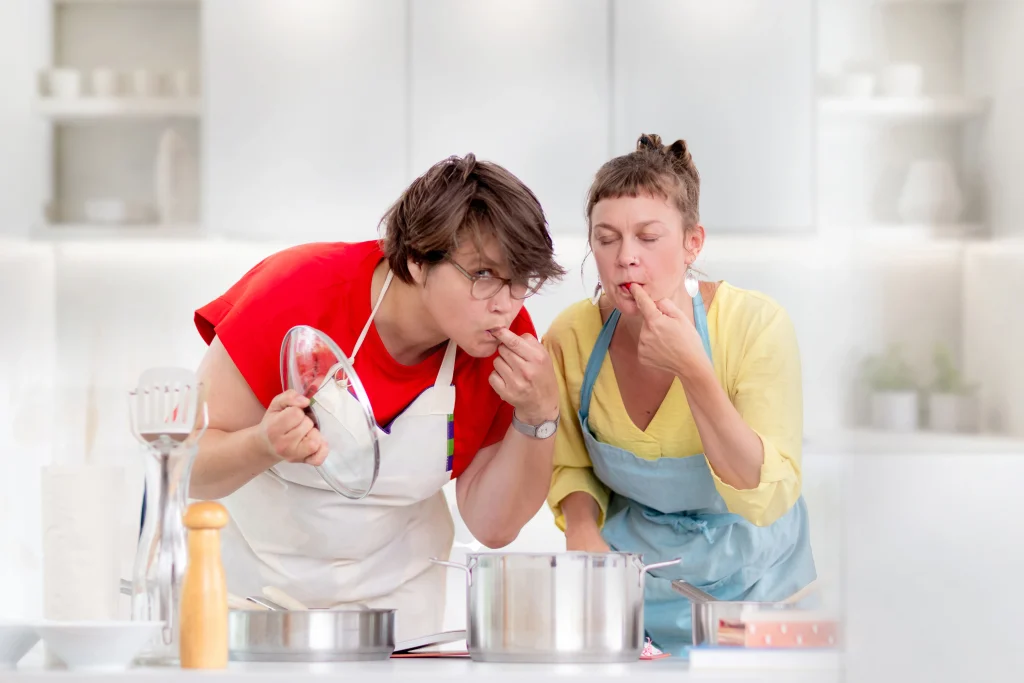 Dorothea und Inga probieren aus einem Topf und genießen.